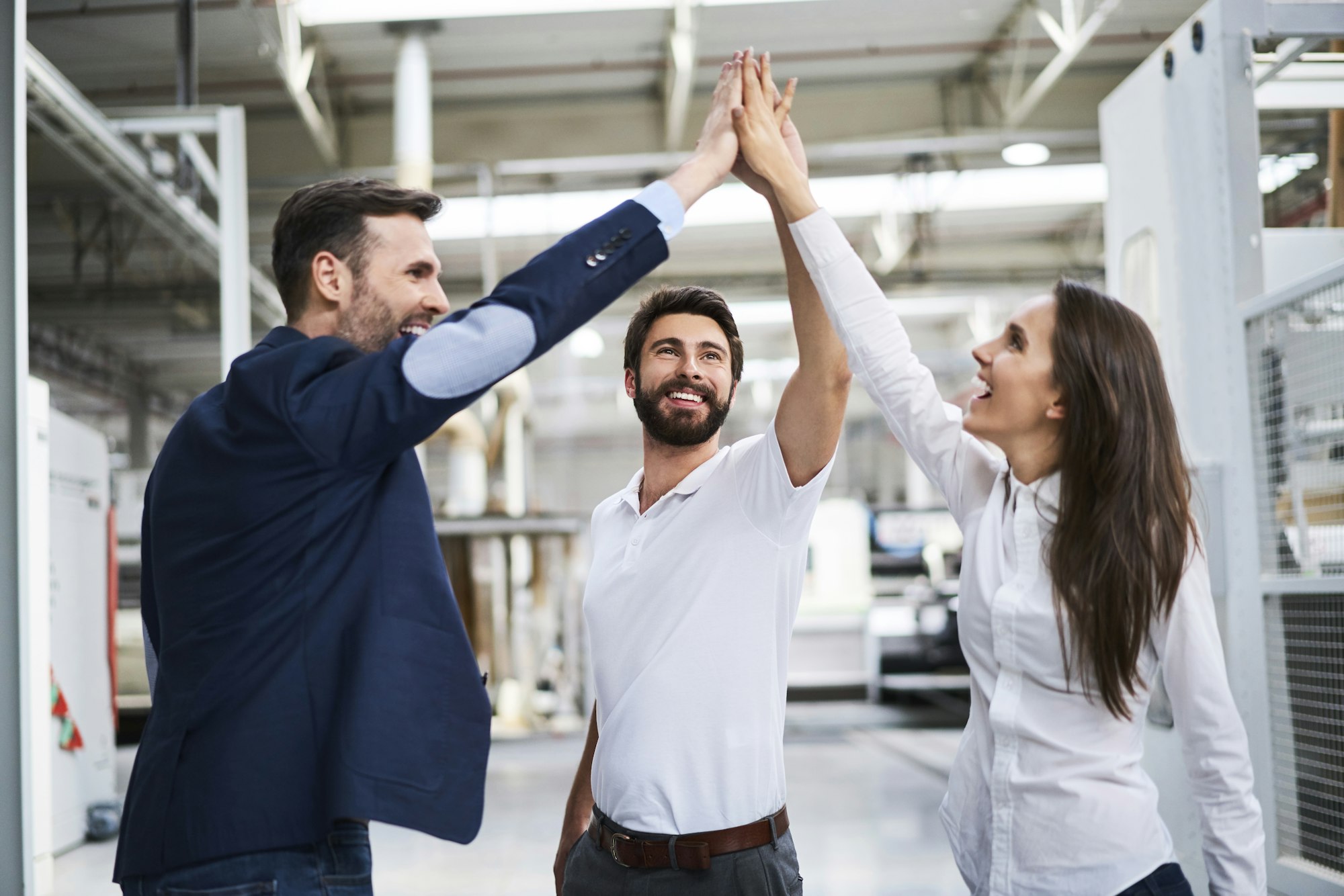 happy-businessman-and-employees-high-fiving-in-a-factory.jpg