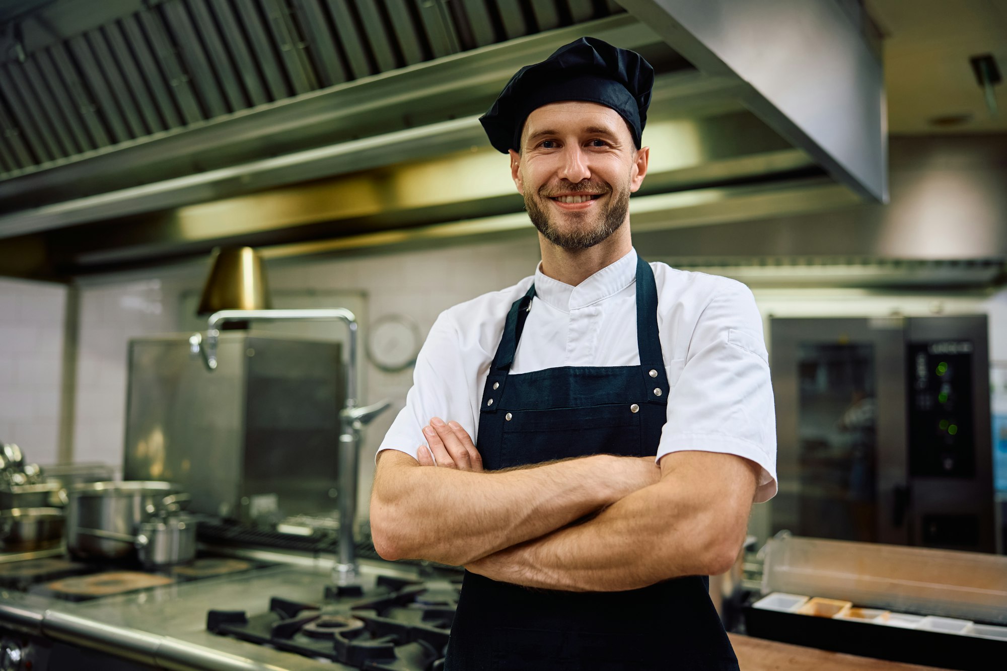 happy-chef-with-arms-crossed-in-the-kitchen-looking-at-camera-.jpg