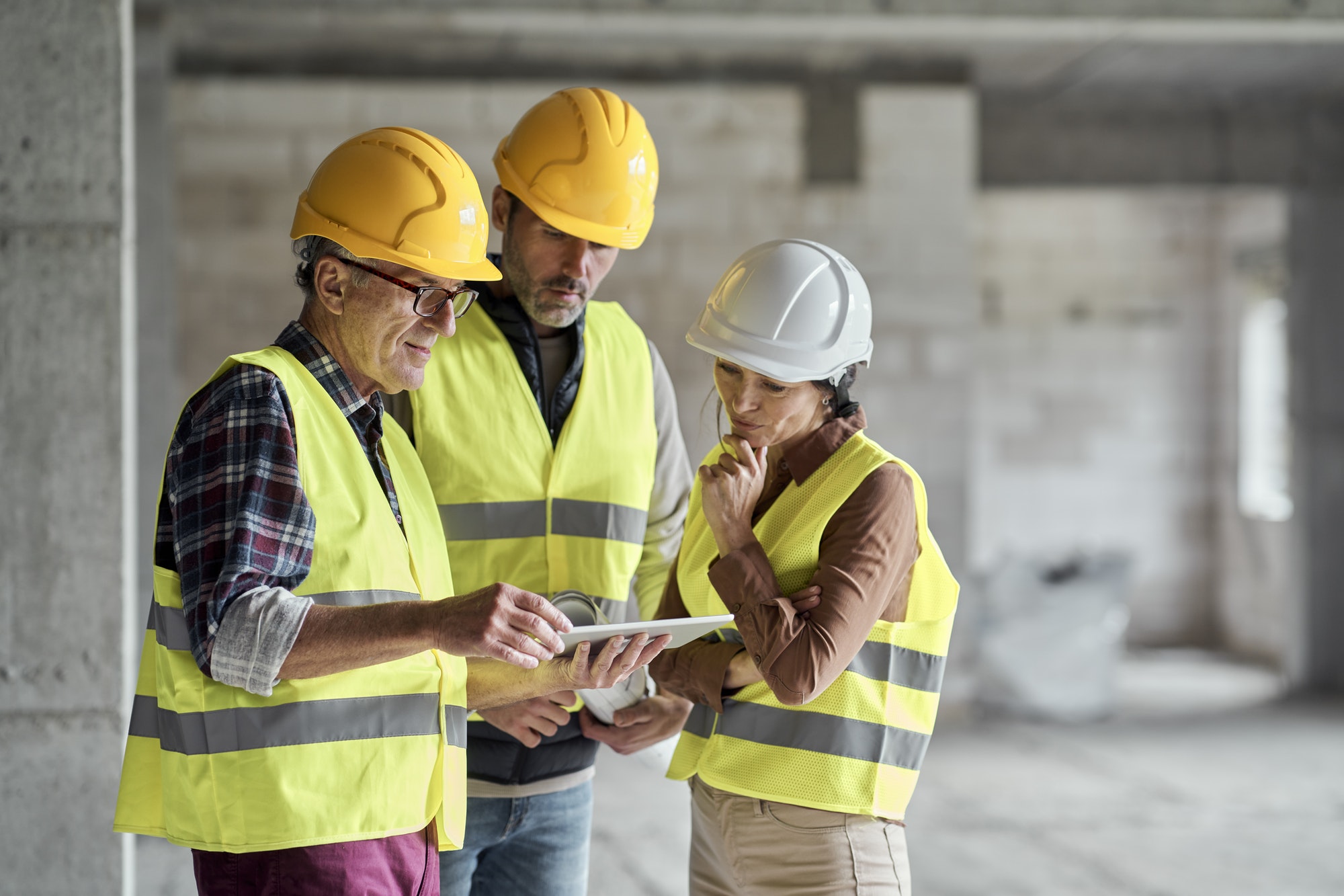 three-caucasian-engineers-discussing-over-digital-tablet-on-the-construction-site.jpg