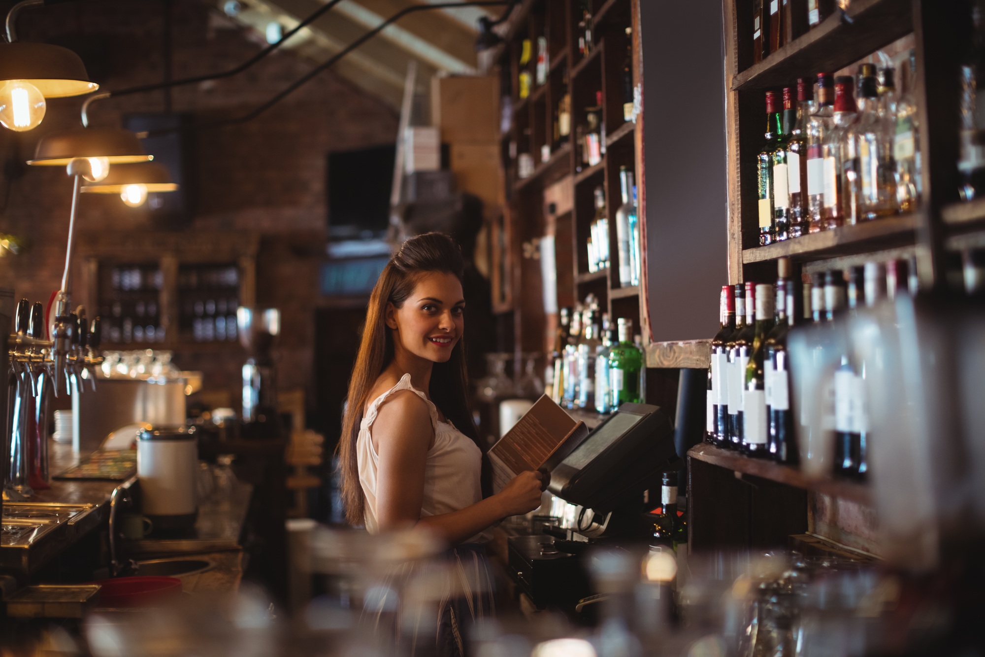 Female bar tender holding menu